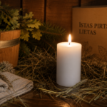 Dekoratīva balta svece novietota uz koka lāvas pirts interjerā. Fonā redzams koka ķipis, pirts slota, linu dvielis un kaste ar uzrakstu "Īstas pirts lietas".