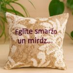 Aromātiskais spilventiņš ar uzrakstu Eglīte smaržo un mirdz uz lina auduma