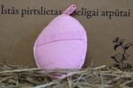 Rozā pirts masāžas spilventiņa aizmugure ar elastīgu roku lenti novietota uz siena fona. Attēlā redzama ovāla forma un mīksts tekstila pārklājums ērtai lietošanai.