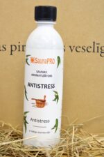 SaunaPRO saunas aromatizētājs "Antistress" uz salmu fona. Attēlā redzama balta plastmasas pudele ar uzrakstu "Antistress", dekoratīvu etiķeti un melnu skrūvējamu vāciņu.