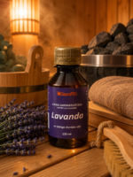 Gaisa aromatizētājs pirtīm ar lavandas aromātu 120 ml tumšā stikla pudelē novietots uz koka galda pirts interjerā. Blakus redzams koka pirts spainis, pirts krāsns akmeņi, salocīti dvieļi un lavandas ziedi.