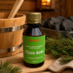 Gaisa aromatizētājs pirtīm ar tējas koka aromātu 120 ml tumšā stikla pudelē novietots uz koka galda pirts interjerā. Blakus redzams koka pirts spainis ar kausiņu, egļu zari un pirts dvielis.