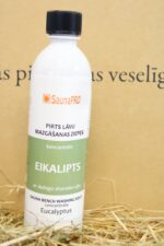SaunaPRO pirts lāvu mazgāšanas līdzeklis "Eikalipts" uz salmu fona. Attēlā redzama balta plastmasas pudele ar zaļi baltu etiķeti un melnu skrūvējamu vāciņu.