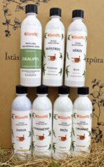 SaunaPRO saunas aromatizētāju kolekcija uz salmu fona. Attēlā redzamas vairākas baltas pudeles ar dažādiem aromātiem, tostarp eikalipts, antistress, bērzs, darva, piparmētra, mežs un lavanda.