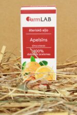 FarmLAB apelsīna ēteriskā eļļa iepakojumā novietota uz salmiem, redzams produkta iepakojums ar apelsīna šķēļu attēlu