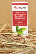 FarmLAB Austrālijas tējas koka ēteriskā eļļa iepakojumā novietota uz salmu paklāja, redzams produkta iepakojums ar tējas koka lapu attēlu