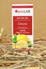FarmLAB citrona ēteriskā eļļa iepakojumā novietota uz salmiem, redzams produkta iepakojums ar citrona šķēļu attēlu