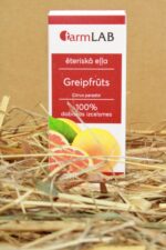 FarmLAB greipfrūta ēteriskā eļļa iepakojumā novietota uz salmiem, redzams produkta iepakojums ar greipfrūta šķēļu attēlu