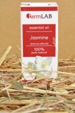 FarmLAB jasmīna ēteriskā eļļa iepakojumā novietota uz salmiem, redzams produkta iepakojums ar jasmīna ziedu attēlu