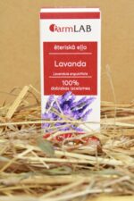 FarmLAB lavandas ēteriskā eļļa iepakojumā novietota uz salmiem, redzams produkta iepakojums ar lavandas ziedu attēlu