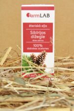 FarmLAB Sibīrijas dižegles ēteriskā eļļa iepakojumā novietota uz salmiem, redzams produkta iepakojums ar čiekuru attēlu