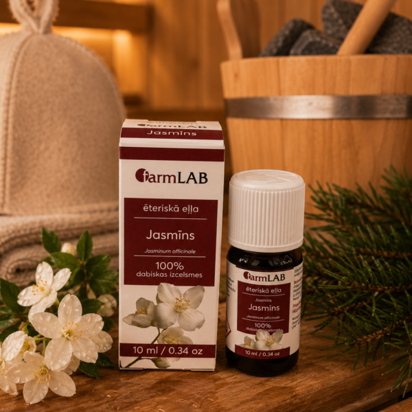 FarmLab ēteriskā eļļa "Jasmīns" 10 ml kopā ar iepakojumu novietota uz koka lāvas pirts interjerā. Blakus redzami jasmīna ziedi, skuju zari, pirts cepure un koka ķipis.