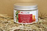 Pirts medus “Mežs” 420 g no farmLAB plastmasas traukā ar baltu vāku, novietots uz salmiem gaišā fonā