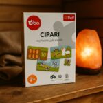 Galda spēles kaste “Cipari” uz koka virsmas pirts telpā, fonā redzama sāls lampa
