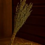 Pirts pušķis no žāvētiem augiem, stāvus novietots pirts telpā uz koka lāvas