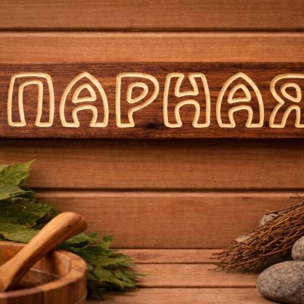 Koka izkārtne “Парная” uz pirts sienas pirts atmosfērā