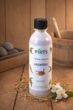 Saunas aromāts “Jasmīns” baltā pudelē uz koka virsmas blakus baltiem jasmīna ziediem