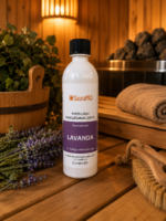Pirts lāvu mazgāšanas līdzeklis ar lavandas aromātu 500 ml baltā pudelē novietots uz koka lāvas pirts interjerā. Blakus redzami lavandas ziedi, koka pirts spainis, pirts krāsns akmeņi un pirts birste.
